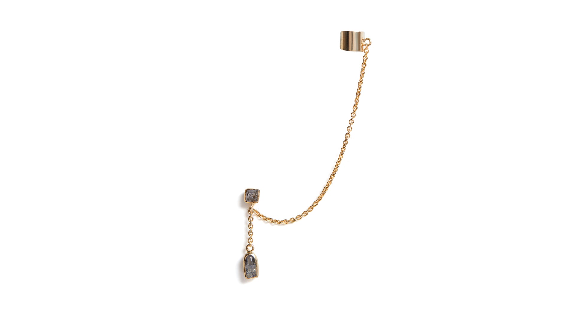 A diamond and sapphire crystal ear cuff in 18ct gold against a white background
