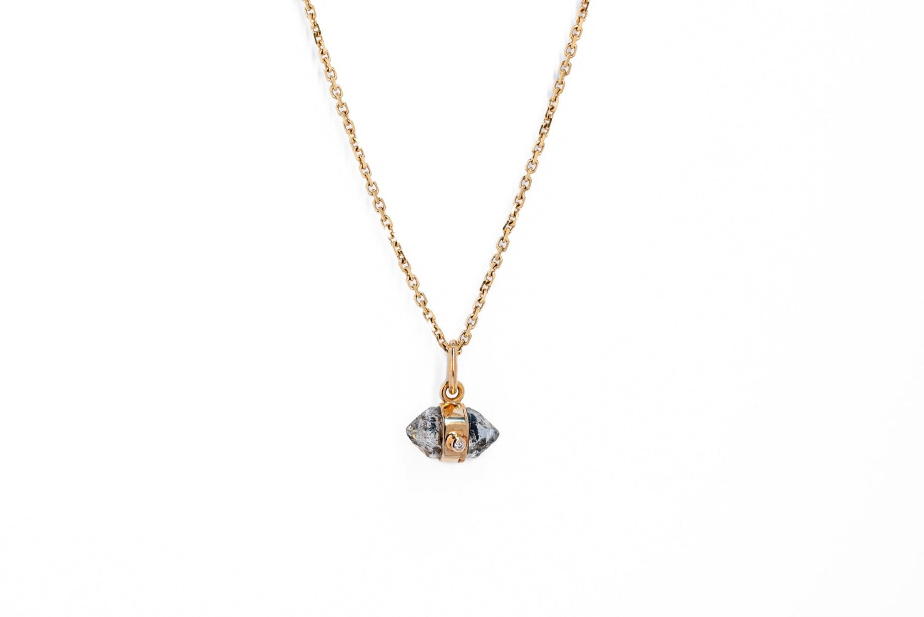 Herkimer quartz and white diamond amulet necklace on a gold chain against a white background
