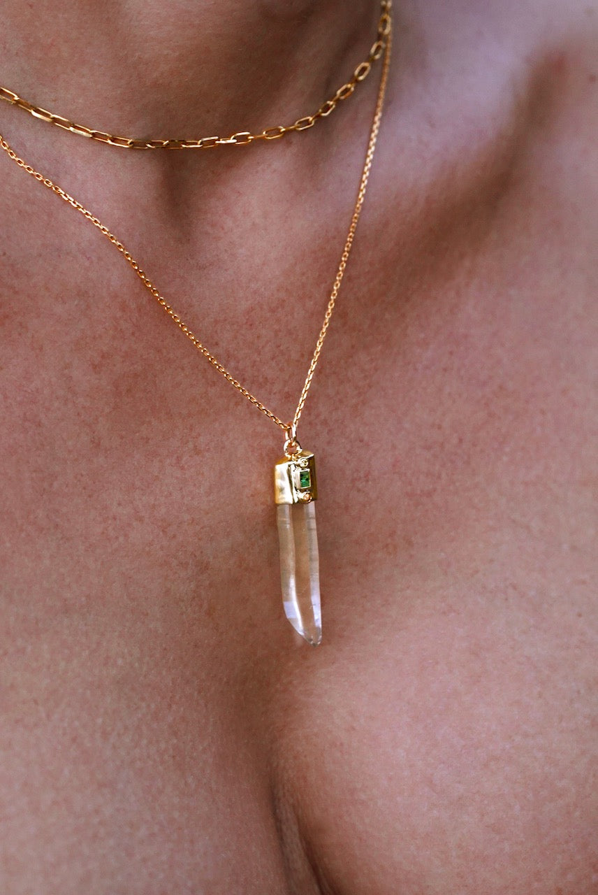 Close up of a models chest wearing Quartz, White Diamond, Emerald and Orange Sapphire Amulet Pendant set in gold. 