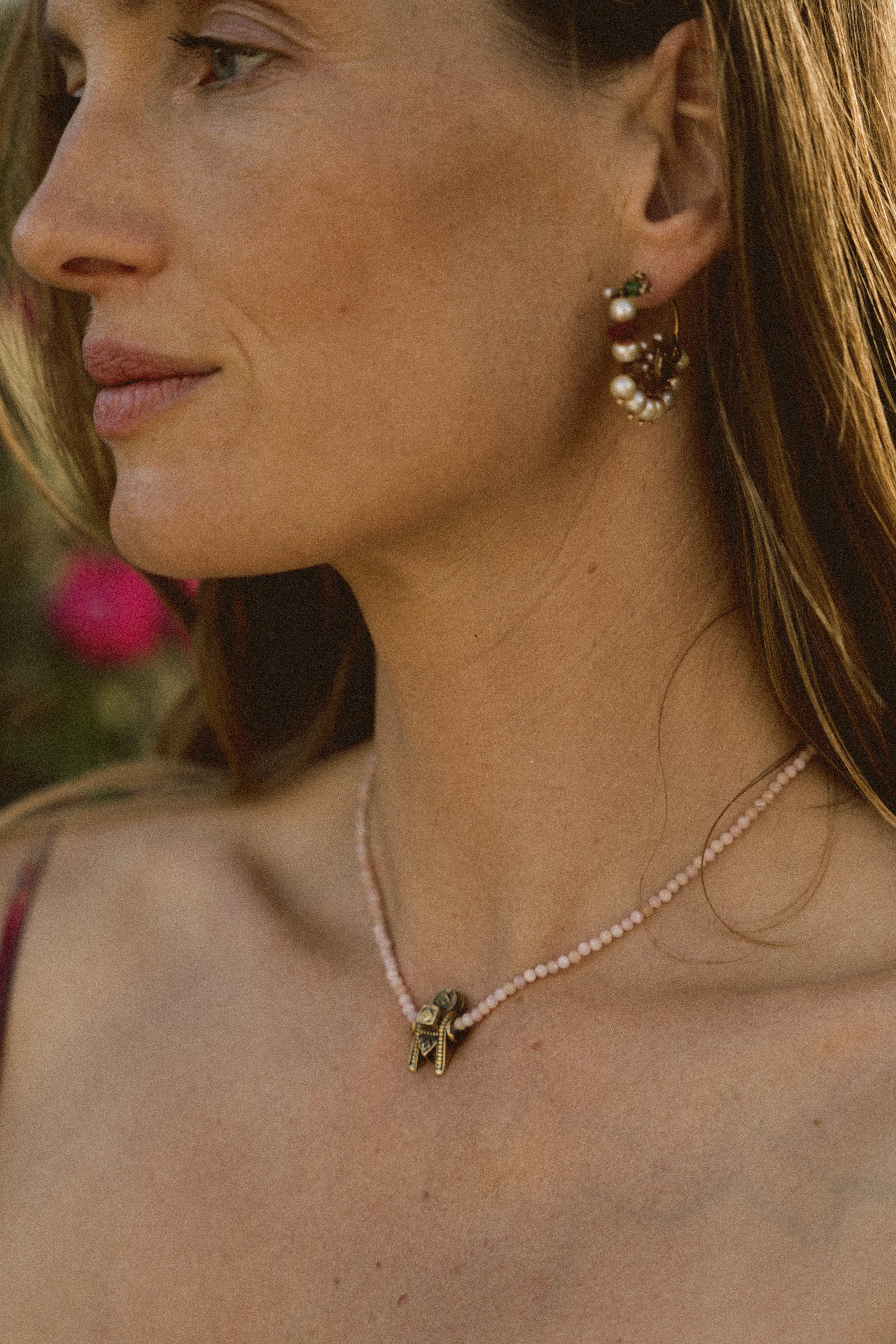 A model wearing a pink beaded necklace with a Thali pendant