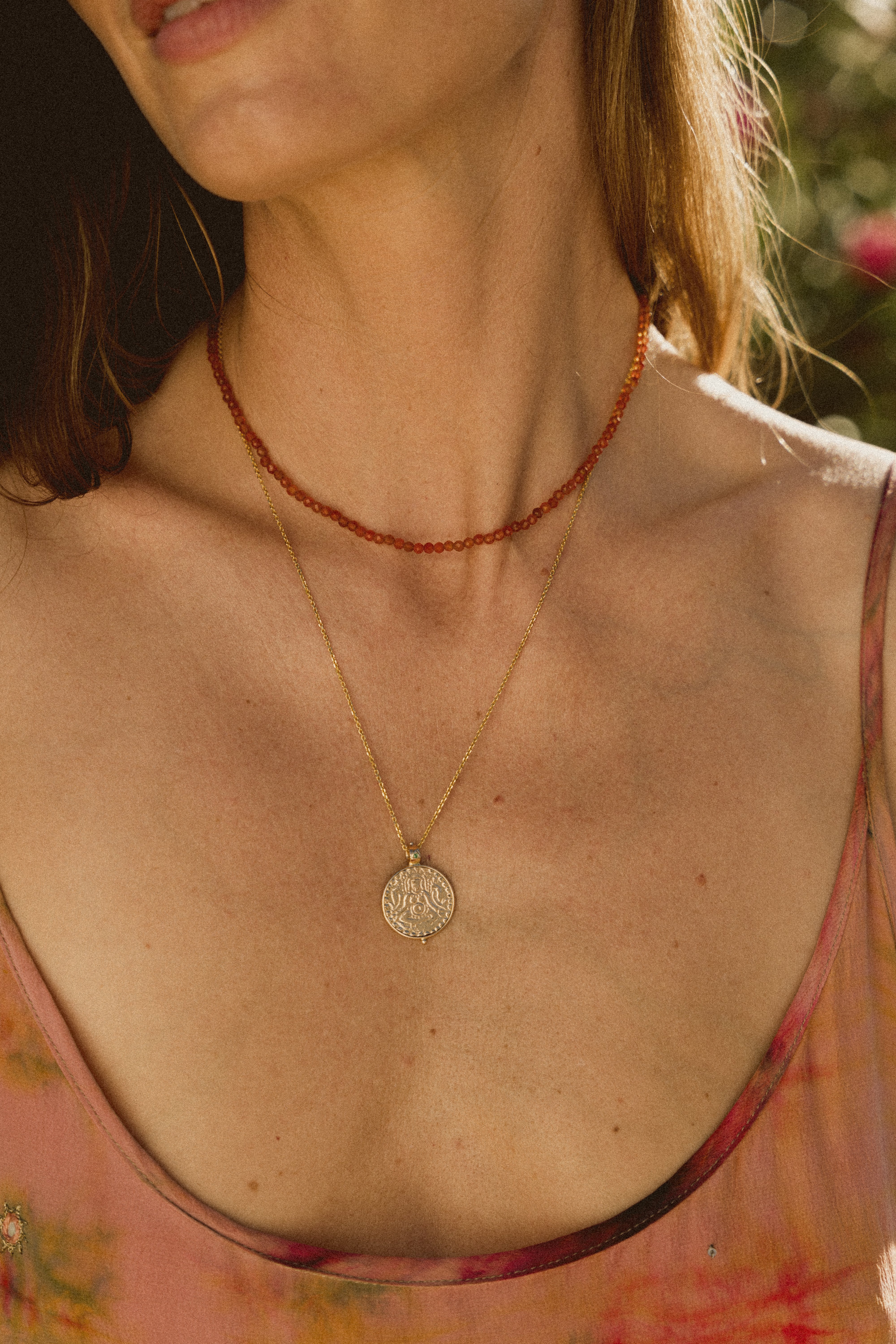 Close up of a model wearing a Carnelian Beaded Necklace with a gold clasp