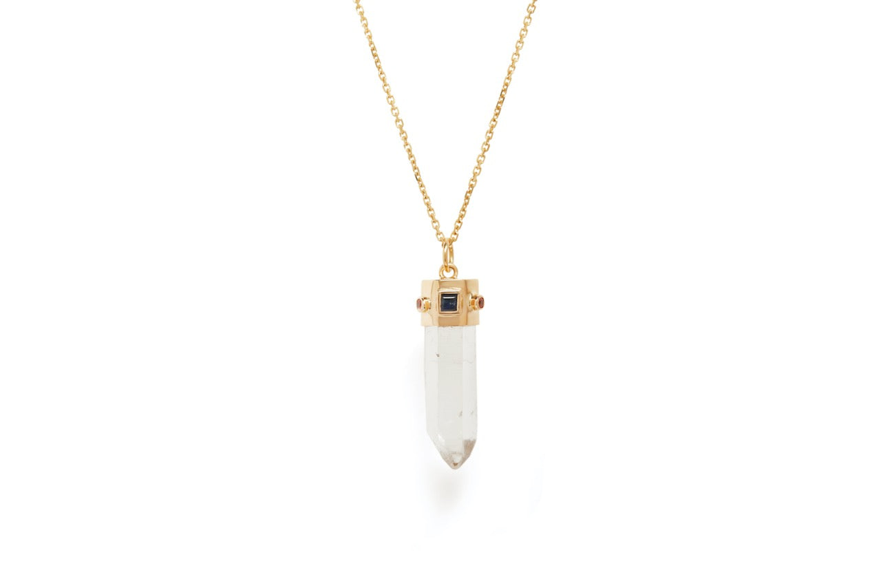 A quartz natural point, blue sapphire and orange sapphire amulet necklace on a gold chain against a white background.