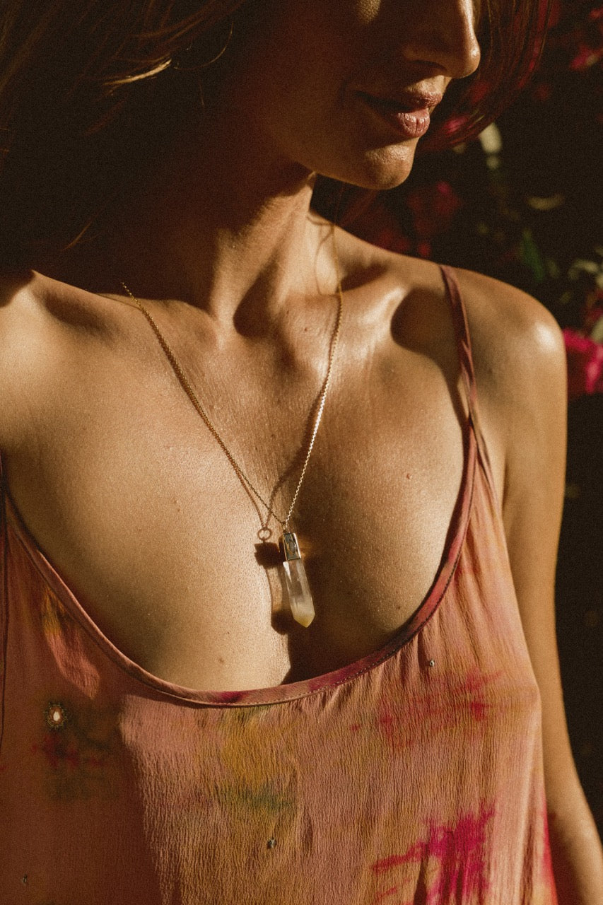 Model in dappled light wearing mango quartz crystal necklace in 18k yellow gold