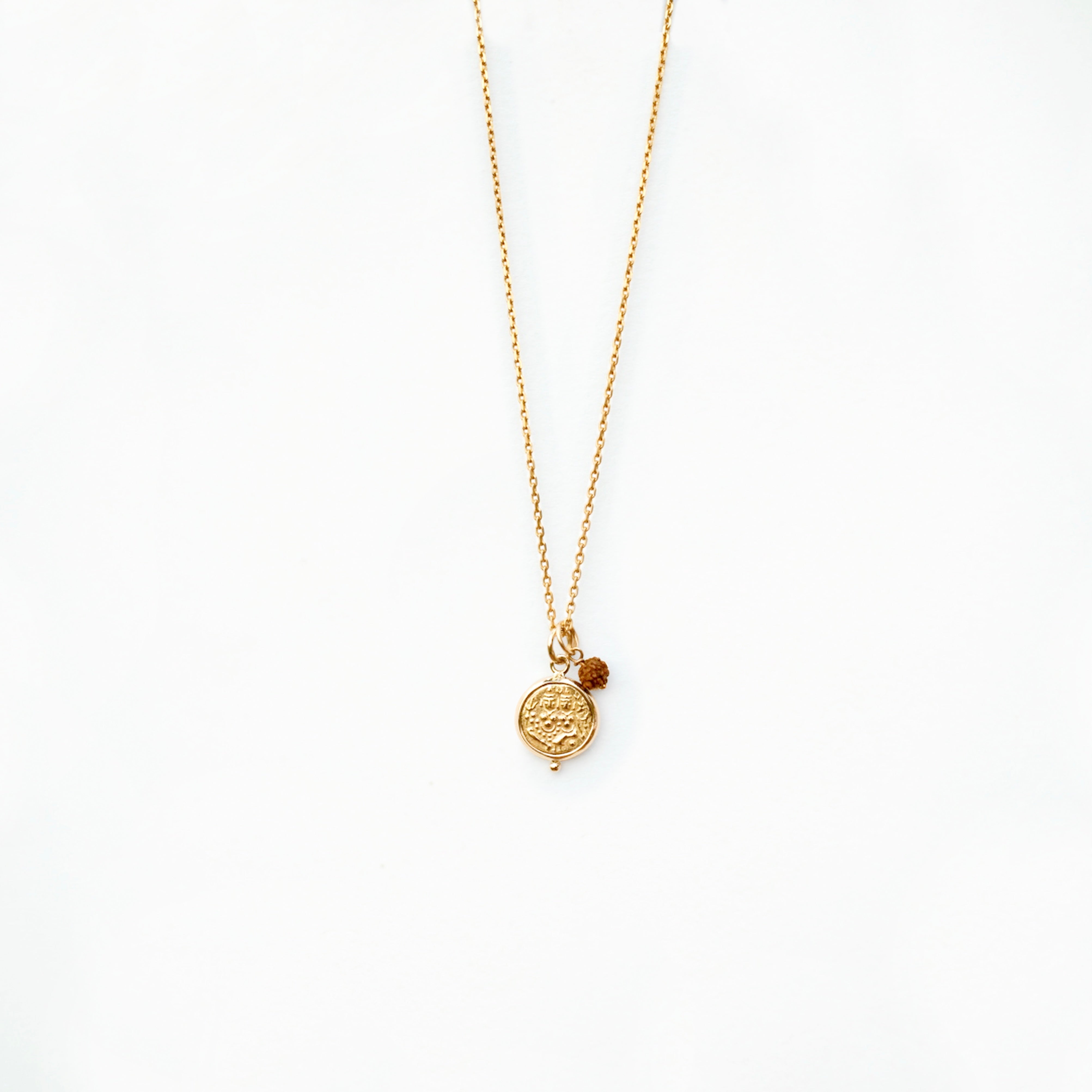 'Union' gold coin necklace with rudraksha charm on chain on white background